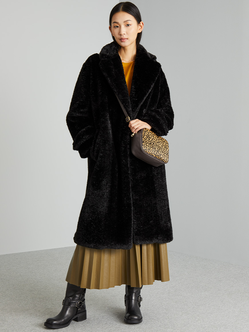 Modella indossa cappotto nero e borsa in fantasia animalier.