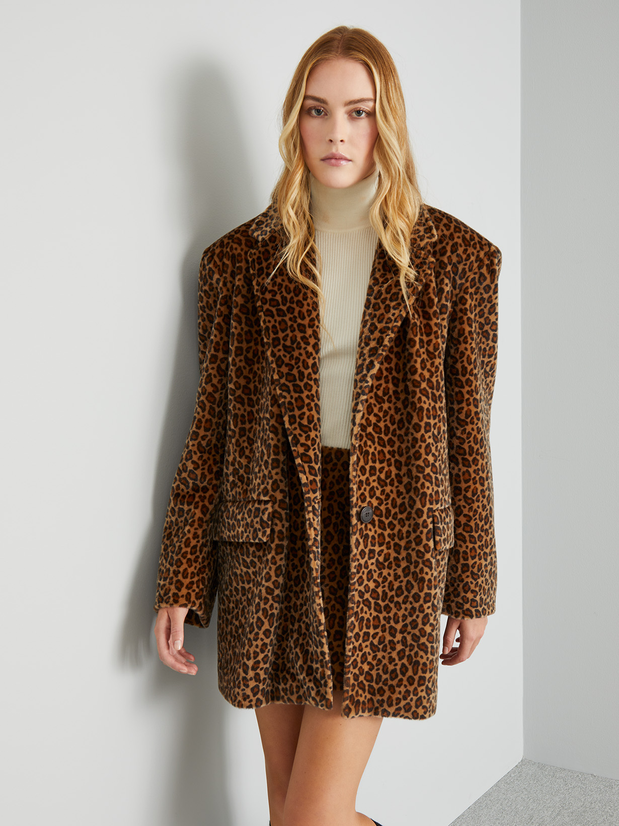 Modella indossa blazer e gonna in fantasia animalier.